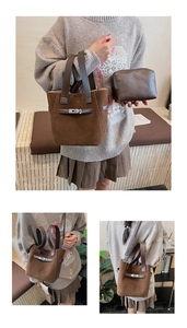 Detail of a brown suede bucket bag with metal buckle closure and inner pouch