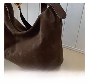 Nahaufnahme der dunkelbraunen Vintage-Veloursledertasche mit Textur und Goldzipper