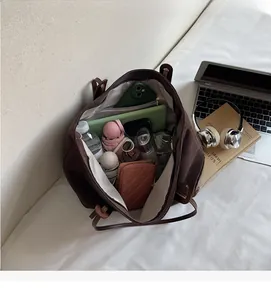 Spacious interior of dark brown tote bag showing capacity for laptop and daily essentials