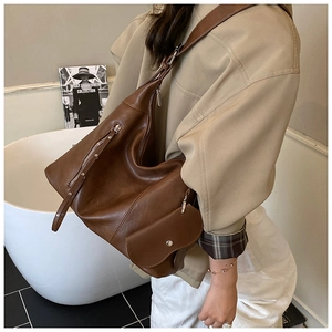 Detail view of brown vintage tote bag showing soft leather texture and functional pockets