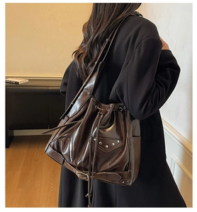 Detail of dark brown bucket bag with silver studs and buckles in a chic punk style