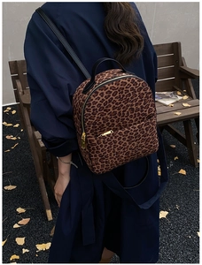 Detailaufnahme des Rucksacks mit Leopardenmuster, Goldreißverschlüssen und Herbst-Look