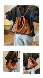 Detail of dark brown lychee grain leather tote showing side zippers and folding design