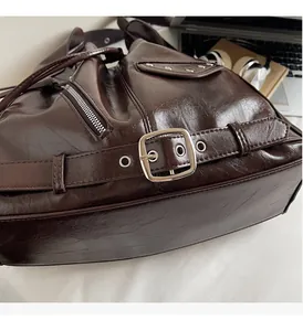 Detail of glossy oil wax leather bag with silver metal buckles and punk style rivets