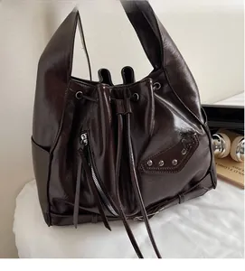 Detail of dark brown leather bucket bag with drawstring closure and wax finish