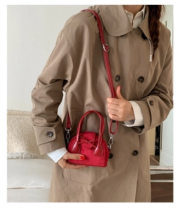Detalle de mini bolso de terciopelo rojo con lazo y una correa de hombro delgada de cuero