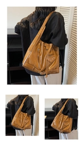 Close-up of vintage brown oil wax leather bucket bag with silver studs and buckles