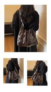 Detail of vintage dark brown bucket bag with silver studs and tassel zippers