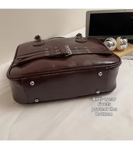 Close-up of durable wear-resistant metal rivets on the bottom of dark brown tote bag