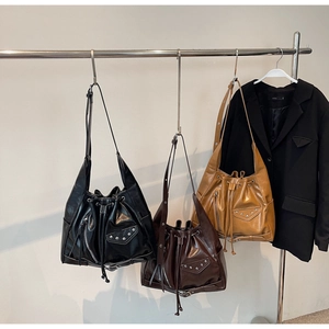 Detail view of motorcycle style bucket bags with rivets and drawstring in three colors