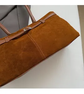 Détail d'un sac cabas en daim marron avec texture douce et coutures soignées