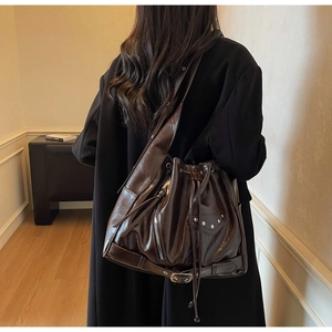 Detailed back view of vintage large brown leather bucket bag with rivet decorations
