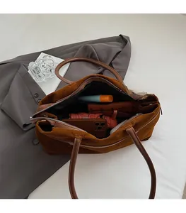 Vue de dessus d'un grand sac cabas en daim marron foncé montrant son énorme espace interne