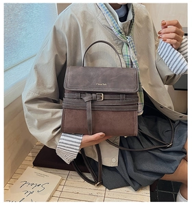 Detail of vintage brown shoulder bag with gold logo and textured leather finish