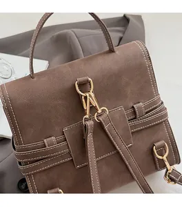 Detail of brown frosted leather handbag featuring premium gold metal clasp and stitching