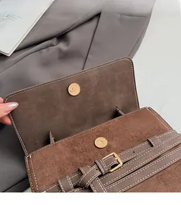 Detail of matte retro messenger bag with magnetic closure and white contrast stitching