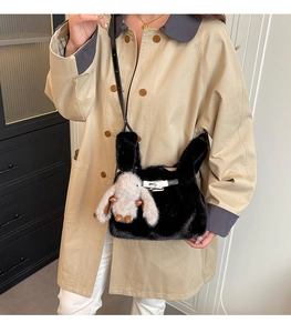 Détail d'un sac à main en fausse fourrure noire avec pendentif lapin et boucle argentée