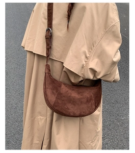 Dettaglio di borsa hobo a mezzaluna in camoscio marrone scuro vintage con tracolla e fibbia argento