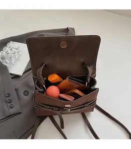 Detail view showing internal capacity for folding umbrella and phone in a dark brown bag