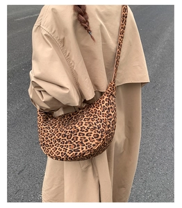 Borsa a mezzaluna chic con stampa leopardata abbinata a un trench beige per un look street
