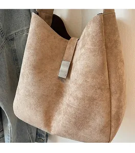 Detail of khaki suede tote bag showing soft texture and silver metal rectangular buckle