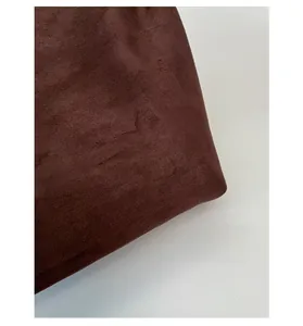 Macro detail of high-quality dark brown suede fabric with fine textured fiber finish