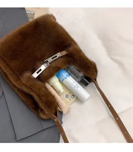 Detail view of brown faux fur shoulder bag showing spacious interior and metal buckle