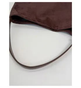 Detail view of large dark brown suede hobo bag with sleek shoulder straps and closure
