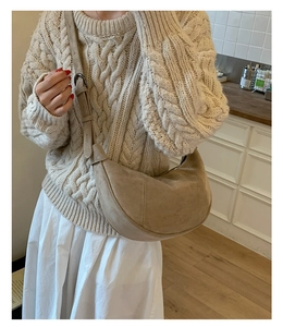 Dettaglio borsa hobo in pelle scamosciata beige con cuciture e tracolla larga