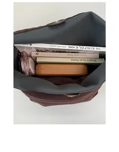 Top view of spacious interior of brown frosted tote bag holding books and daily items