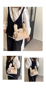 Detail view of plush beige bunny handbag featuring classic metal twist lock and leather strap