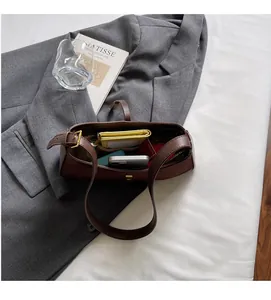 Draufsicht auf die braune Ledertasche mit Reißverschlussfach und Alltagsutensilien