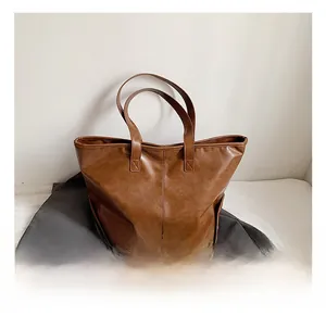 Detailaufnahme der braunen Ledertasche mit Vintage-Textur und doppelten Riemen