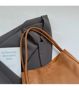 Detail showing comfortable thin shoulder straps of the suede caramel tote bag