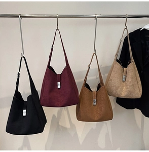 Detail of four matte suede tote bags in black, burgundy, brown, and beige with metal buckles