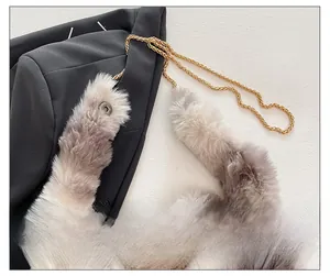 Close-up of fluffy faux fur shoulder bag with gold woven chain strap and magnetic clasp
