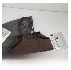 Flat lay of large dark brown suede tote bag with tablet and office accessories