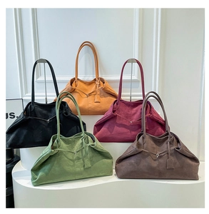 Five suede tote bags in black, burgundy and coffee displayed on minimalist white stands