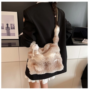 Détail du sac cabas en peluche beige et crème avec un charmant pompon sur l'anse