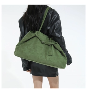 Grand cabas en daim vert mousse avec boucle décorative porté par un mannequin