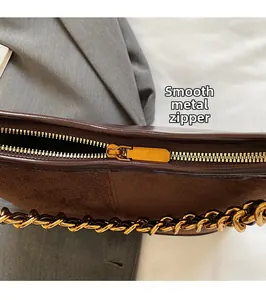 Detail of premium gold zipper and smooth leather texture on vintage brown shoulder bag