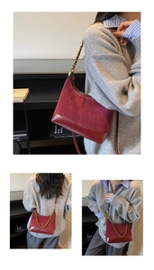 Detail view of burgundy patchwork shoulder bag with gold chain strap on model