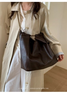Détail du sac cabas vintage marron foncé avec texture huilée et bandoulière en chaîne
