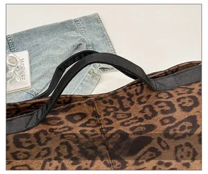 Close-up of leopard print tote bag featuring black handle and detailed stitching