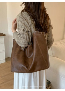 Vue détaillée du sac cabas en cuir marron vintage avec bandoulière en chaîne métallique