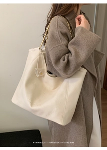 Détail du sac cabas beige minimaliste avec chaîne dorée et logo embossé sur cuir souple