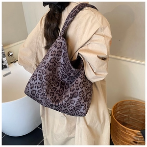 Back view of model wearing a large leopard print tote bag with a minimalist bucket design