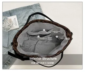 Detailed interior of leopard print tote bag with striped lining and functional pockets