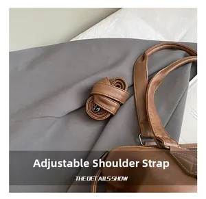 Detail shot of adjustable brown PU leather shoulder strap with durable metal hardware