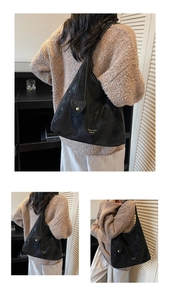 Λεπτομέρεια macro του χρυσού λογότυπου σε μαύρη vintage hobo τσάντα από ματ δέρμα